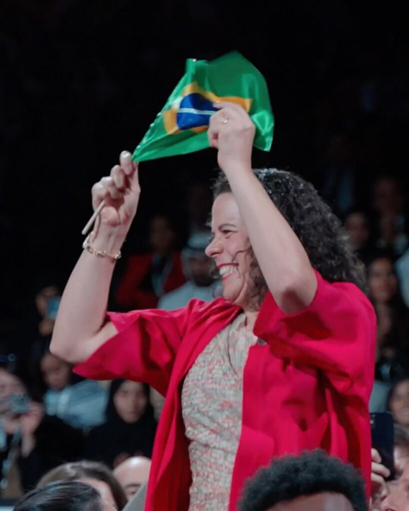 Marilia Lara, CEO da Stattus4, com a bandeira do Brasil comemora a vitória no Prêmio Zayed de Sustentabilidade.