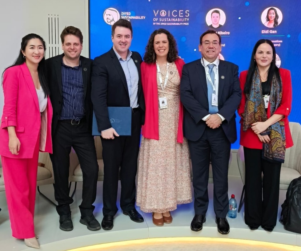 Grupo de vencedores do Prêmio Zayed de Sustentabilidade reunidos no palco: Marilia Lara, da Stattus4, posa ao lado de líderes das organizações premiadas de Singapura, Suíça, Nepal e Emirados Árabes.